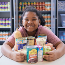 girl holding canned goods at food pharmacy