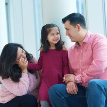 hospital patient in window smiling with parents