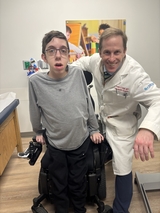 Eli stands with his spine surgeon Dr. Cahill