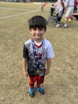 Jayant poses on field with soccer medals