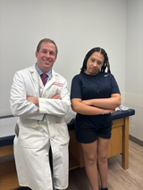 Dr. Cahill and patient Amirah stand together in clinic office at a follow up visit