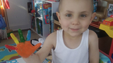 Boy hospital patient finger painting and smiling