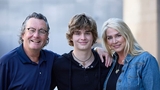 Johnny with his parents outside