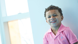 Cruz smiling wearing in a pink shirt