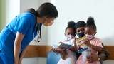 Doctor with mom and her daughters in exam room