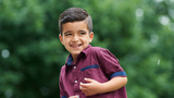 Elijah smiling outside