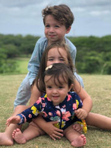 three kids outside smiling