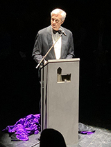 Dr. Adzick speaks at the podium, minus his cloak
