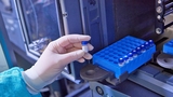 Gloved hand holding a test tube Gloved hand holding a test tube