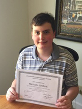 Harrison sitting at table with certificate