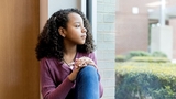 Adolescent girl sadly looking out window Adolescent girl sadly looking out window