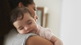 Mother holding sleeping infant