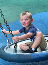 Hudson riding a tire swing