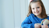 Young girl cancer patient smiling with stuffed animal