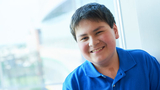 Young cancer patient sitting in hospital window smiling
