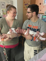 Mom and Dad holding Erin and Abby joined at the head