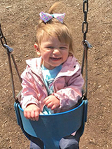 Ava sitting in a swing