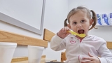 Young girl eating with a spoon Young girl eating with a spoon