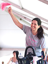 Philly Spin-In participant riding a bike and waving a towel