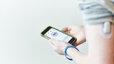 Teen using mobile app to monitor glucose level Teen using mobile app to monitor glucose level
