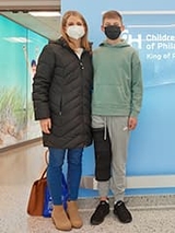 Liam standing next to his mom