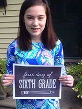 Kate holding up a 6th grade school poster