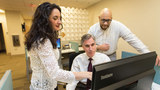 Three clinicians looking at a computer display