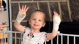 Madelyn after surgery showing her wrapped hands