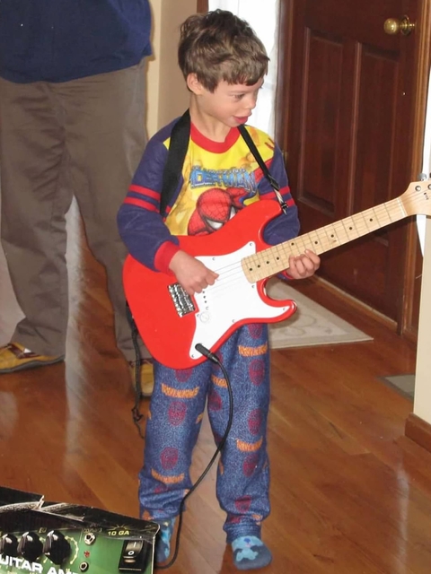 Nicholas playing guiter as a young boy