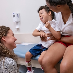 Emma McKenzie, a physical therapist in the Seating Clinic, greets Apollo, 4, who has cerebral palsy, and his mother, Lesana.