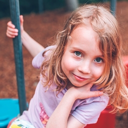 The girl is smiling.