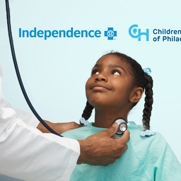 Girl looking up at a healthcare professional who is holding a stethoscope.