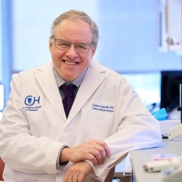 Dr. Grupp wearing a white coat in a lab Dr. Grupp wearing a white coat in a lab