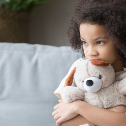 Scared young girl holding a stuffed animal Scared young girl holding a stuffed animal
