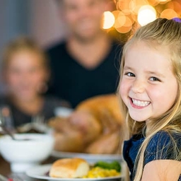 Young girl smiling at Thanksgiving table