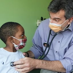 Doctor listening to young boy's heartbeat Doctor listening to young boy's heartbeat