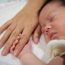 Infant holding onto finger Infant holding onto finger