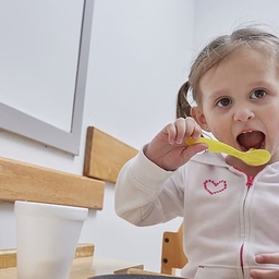 Young girl eating with a spoon Young girl eating with a spoon