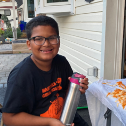 Liam smiling while carving a pumpkin