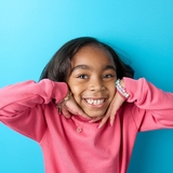 Girl smiling with hands up to her cheeks