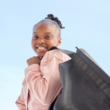 Smiling CHOP patient holding shopping bag