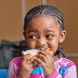 Yougn girl eating sandwhich
