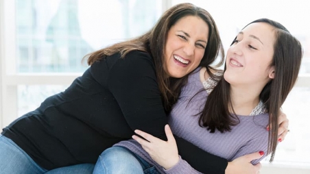 Mother excitedly embracing daughter