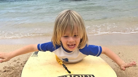 Max on his surfboard at the beach