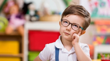 Young boy with glasses thinking
