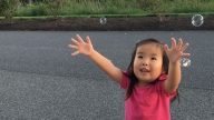 Avery playing with bubbles outside