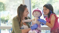 Child Life worker playing dolls with oncology patient