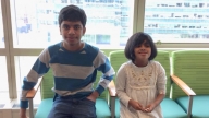 Yusuf and Khadija smiling sitting on chairs together