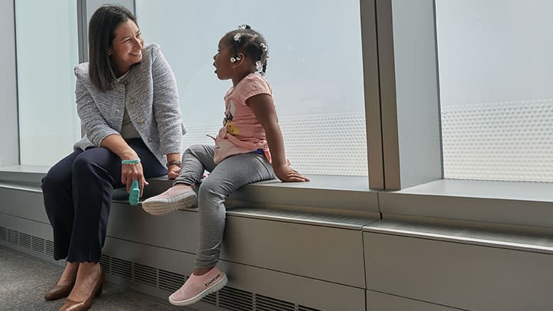 Doctor talking to child next to window