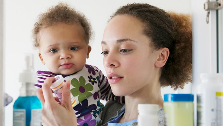 Mom reading label with baby